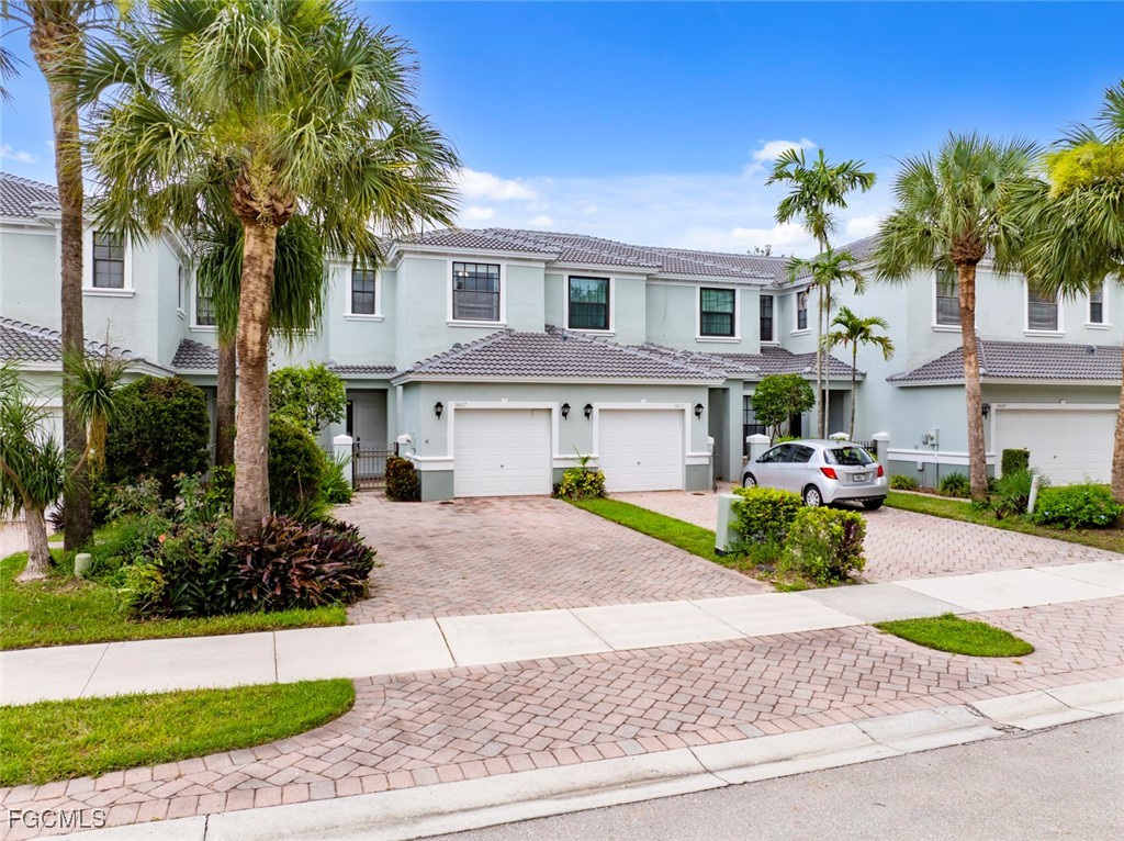 14617 Sutherland Avenue, Unit 80 Naples, FL 34119 - Photo 2 of 46 a front view of a house with a yard and potted plants