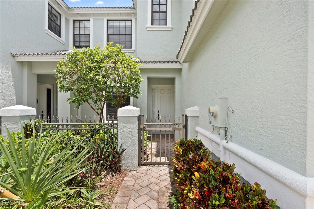 14617 Sutherland Avenue, Unit 80 Naples, FL 34119 - Photo 3 of 46 a front view of a house with a garden