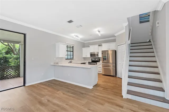a kitchen with stainless steel appliances a refrigerator and wooden floor