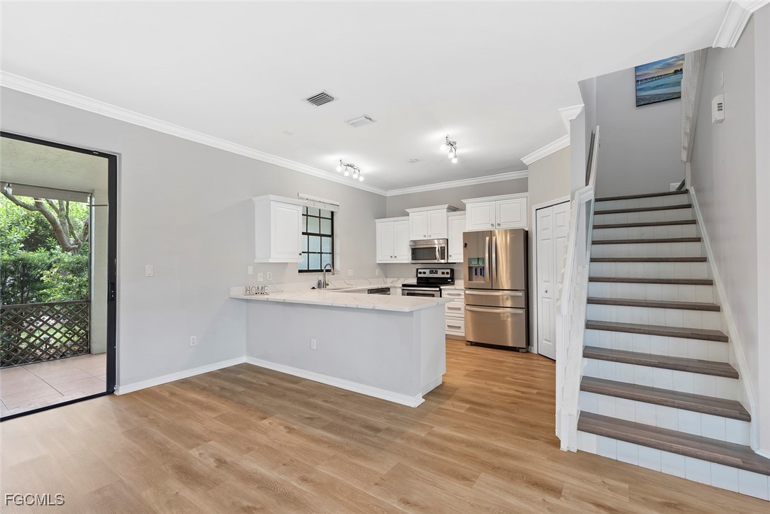 14617 Sutherland Avenue, Unit 80 Naples, FL 34119 - Photo 8 of 46 a kitchen with stainless steel appliances a refrigerator and wooden floor