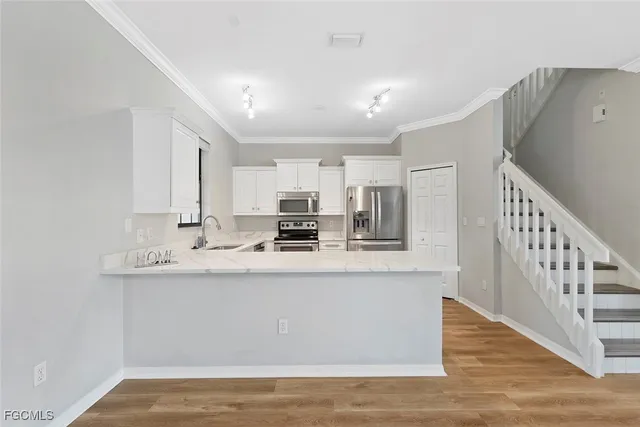 a view of kitchen with stainless steel appliances granite countertop refrigerator sink and stove