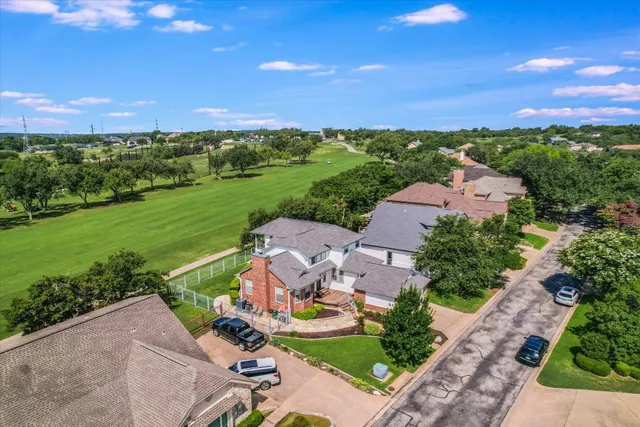 an aerial view of residential houses with outdoor space and lake view