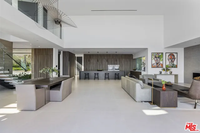 a large living room with stainless steel appliances kitchen island granite countertop furniture and a kitchen view