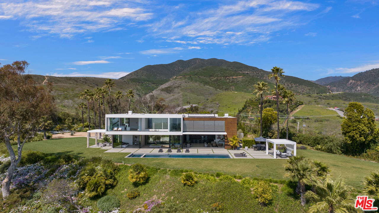 5601 Kanan Dume Road Malibu, CA 90265 - Photo 7 of 31 a view of a swimming pool with a table under an umbrella