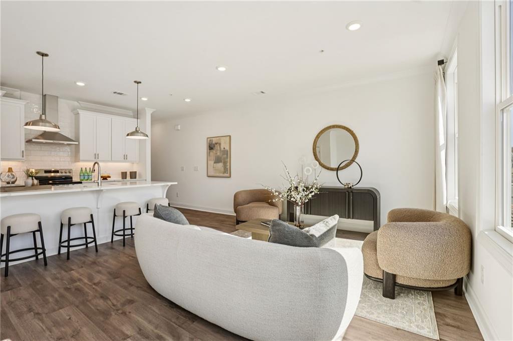 532 Alice Way, Unit D8 Cumming, GA 30040 - Photo 11 of 40 a living room with couches a coffee table and kitchen view with wooden floor