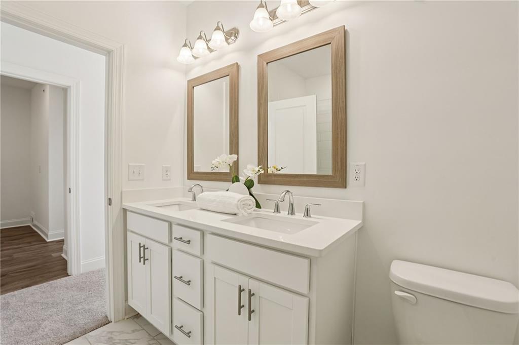 532 Alice Way, Unit D8 Cumming, GA 30040 - Photo 27 of 40 a bathroom with a toilet sink and mirror