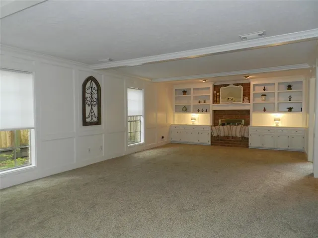 a view of empty room with a fireplace and windows