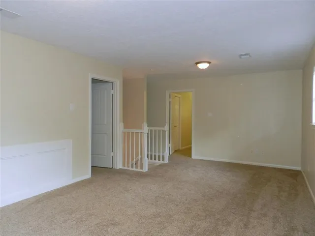 an empty room with staircase and door