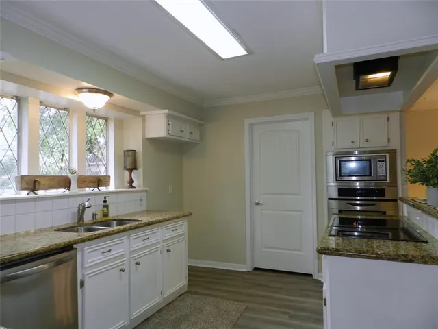 a kitchen with granite countertop a refrigerator and a sink