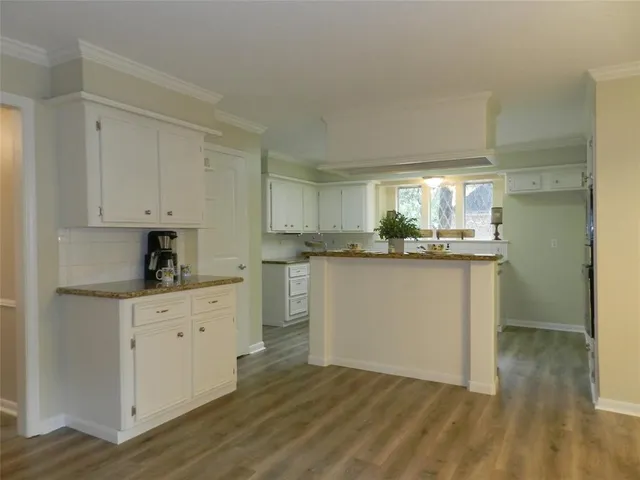 a kitchen with stainless steel appliances granite countertop a stove a sink and white cabinets