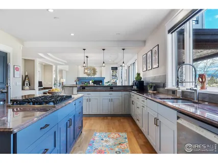 a kitchen with stainless steel appliances granite countertop a stove a sink dishwasher and cabinets with wooden floor