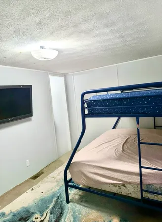 a bedroom with a bed and a flat screen tv