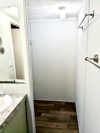 a view of a small house with a wooden fence