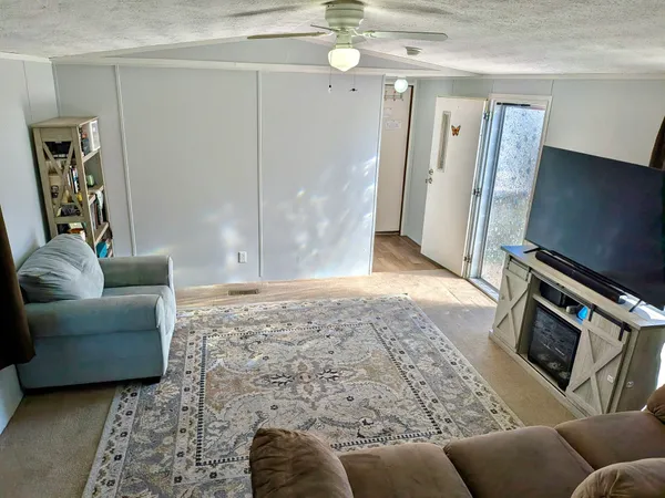 a living room with furniture a flat screen tv and a fireplace
