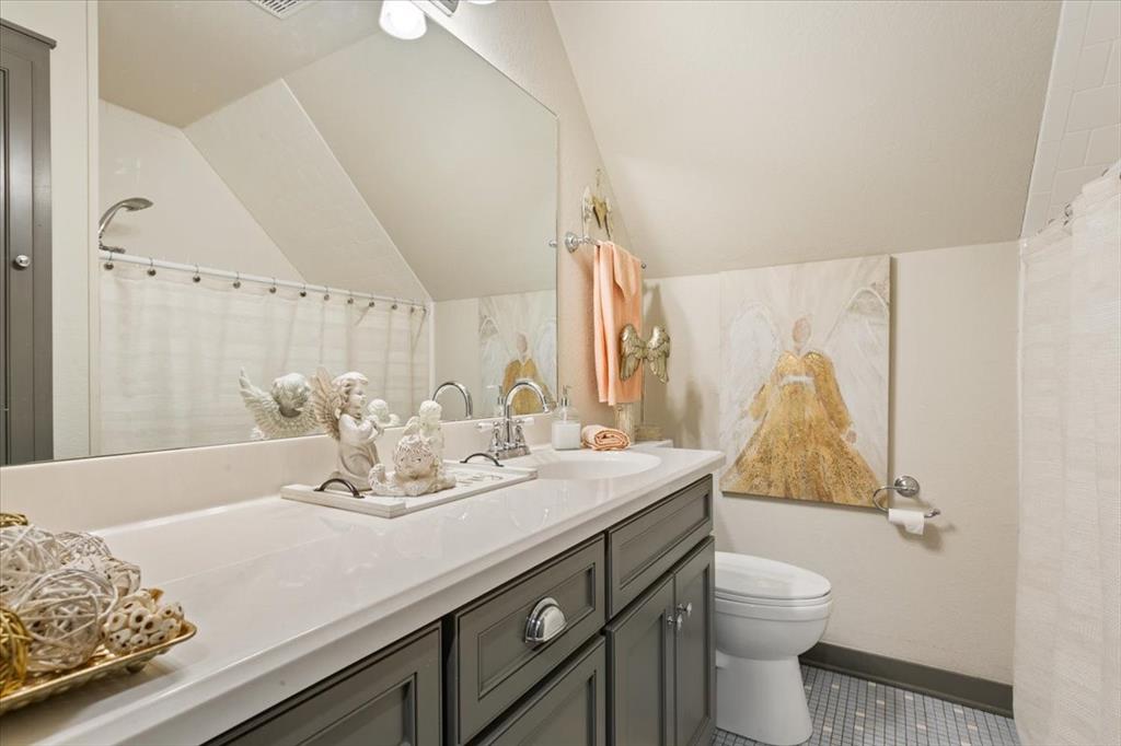 649 Wedgewood Drive China Spring, TX 76633 - Photo 18 of 39 Bathroom featuring a shower with shower curtain, vanity, vaulted ceiling, and dark tile patterned flooring