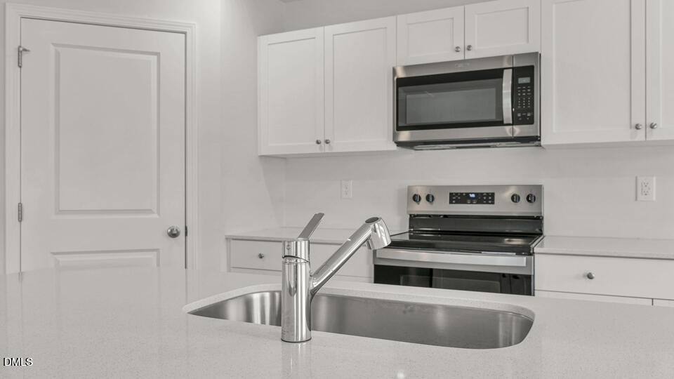 629 Stream Walk Crossing Wendell, NC 27591 - Photo 11 of 38 a kitchen with stainless steel appliances white cabinets and a stove top oven