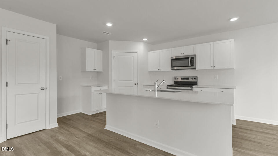 629 Stream Walk Crossing Wendell, NC 27591 - Photo 8 of 38 a kitchen with stainless steel appliances a stove top oven a sink a refrigerator a microwave and cabinets