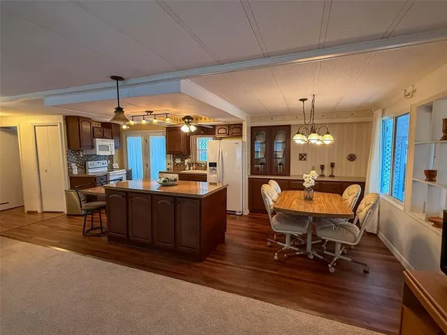 a living room with couches a dining table chairs with wooden floor