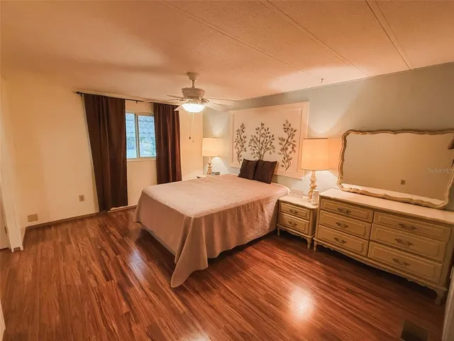 a spacious bedroom with a bed and a night stand