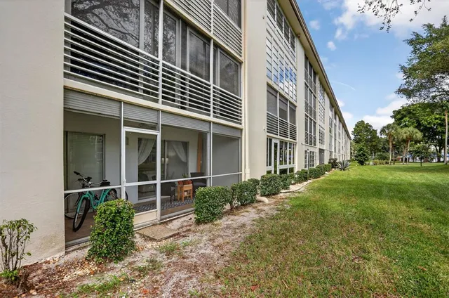 a outdoor space with lots of tables a large window and chairs