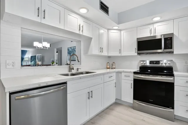 a kitchen with stainless steel appliances granite countertop a stove a refrigerator and a microwave