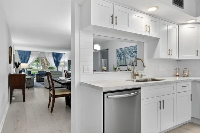 a view of a dining room and livingroom with furniture wooden floor a chandelier