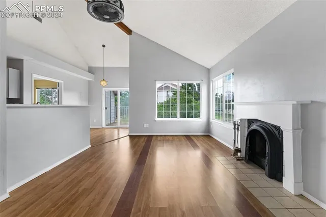 a view of a livingroom with fireplace wooden floor and windows