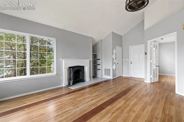 a view of an empty room with a fireplace and a window