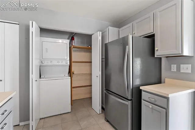 a kitchen with stainless steel appliances a refrigerator a sink a stove and white cabinets
