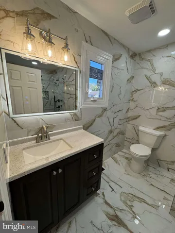 a bathroom with a double vanity sink mirror and toilet
