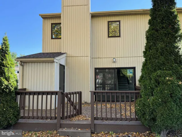 a view of a house with a small yard and wooden fence