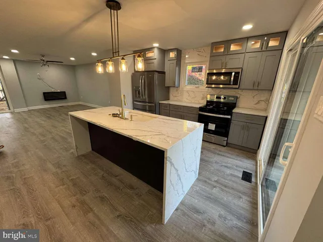 a large kitchen with stainless steel appliances a large counter top