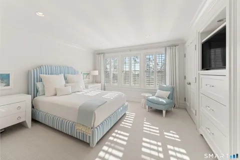 a bedroom with a bed and a large window