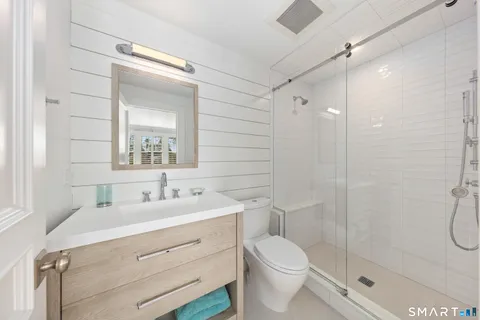 a bathroom with a double vanity sink toilet and shower