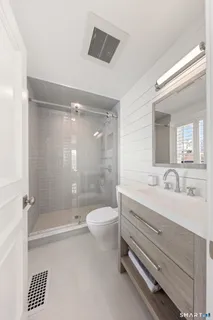 a bathroom with a double vanity sink toilet mirror and bathtub
