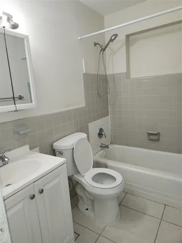 a white toilet and tub sitting next to a bathroom sink