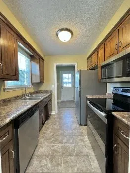a kitchen with stainless steel appliances granite countertop a sink stove and cabinets