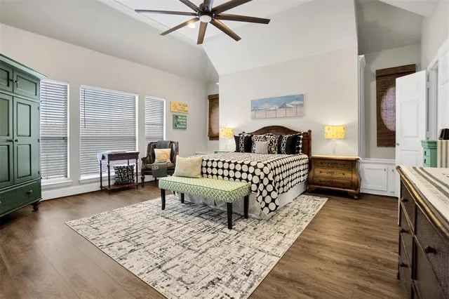 a spacious bedroom with a bed a couch and a chandelier