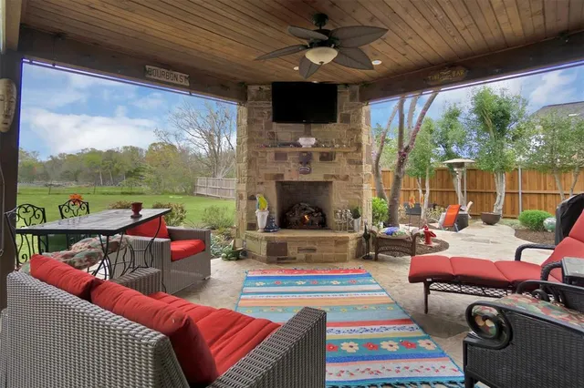 a living room with patio fireplace furniture and a floor to ceiling window