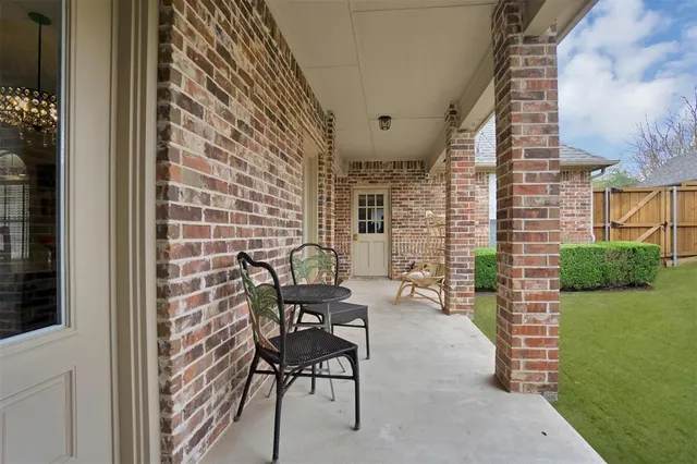 a patio with table and chairs and potted plants