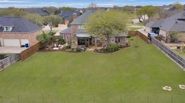 a view of a house with a big yard and large trees