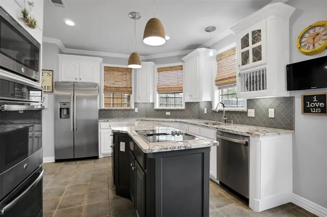 a kitchen with stainless steel appliances granite countertop a stove a sink and a refrigerator