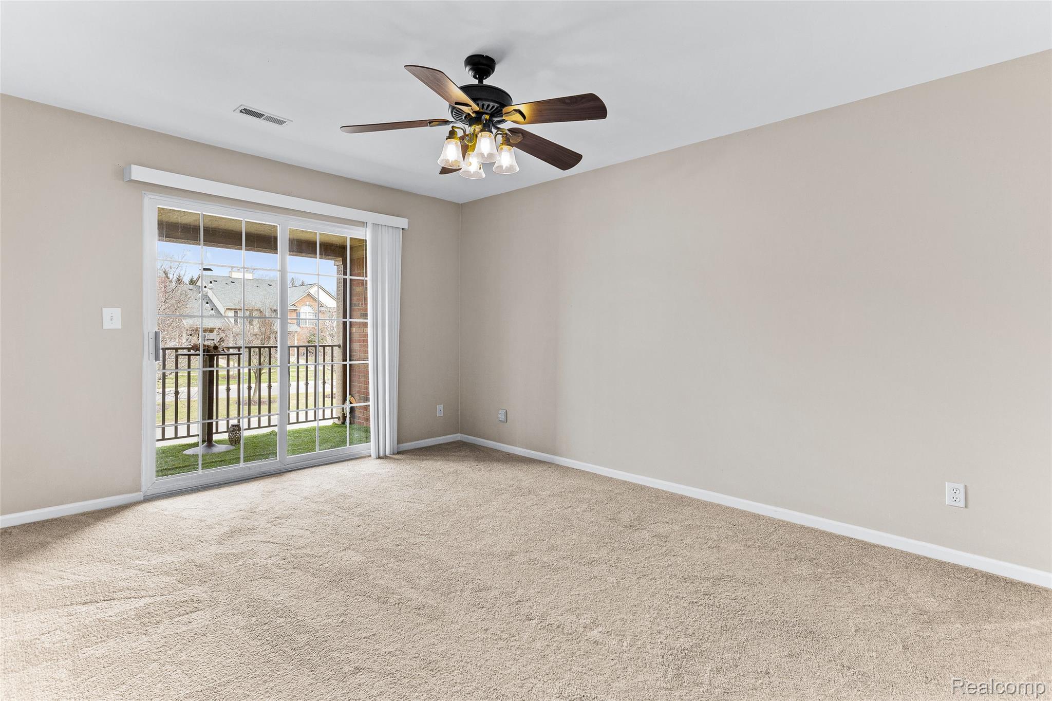 3553 Oakmonte Boulevard Rochester, MI 48306 - Photo 12 of 42 Carpeted room featuring a ceiling fan with light fixture and a sliding glass door opening to a balcony with black metal railings