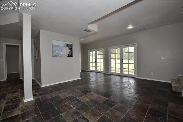 a view of a hallway with a dining table and chairs