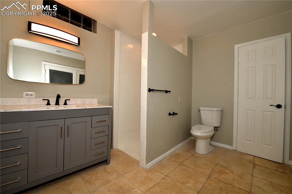 1275 Berglind Road Colorado Springs, CO 80920 - Photo 26 of 30 a spacious bathroom with a toilet sink and mirror