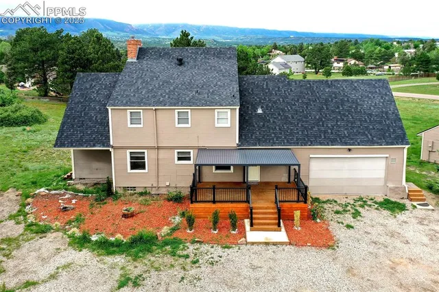 an aerial view of a house with garden space and a street view