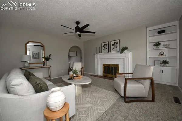 a living room with furniture a rug and a fireplace