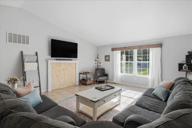 a living room with furniture a flat screen tv and a large window