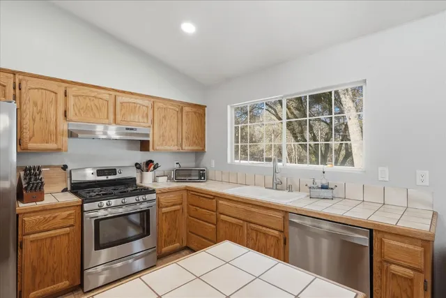 a kitchen with a sink stove top oven and cabinets