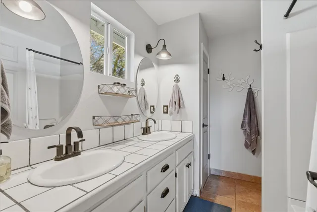 a bathroom with a double vanity sink and mirror